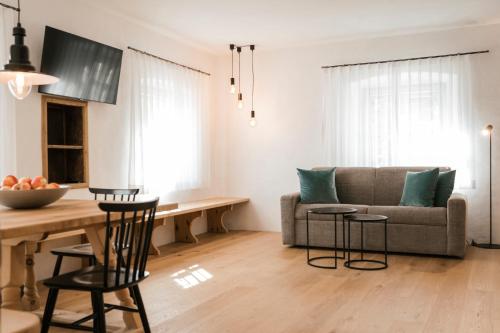a living room with a couch and a table at St. Vigilius modern historic apartments in Nalles
