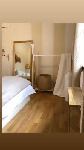 a bedroom with a white bed and a mirror at Ela Apartments Berlin in Berlin