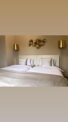 a bedroom with two beds with white sheets and gold lights at Ela Apartments Berlin in Berlin