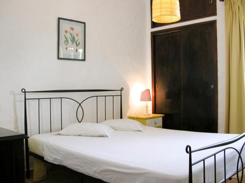 a bedroom with a bed with white sheets and a door at Baiona Club Villa 19 in Porches