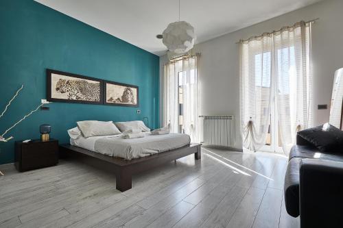 um quarto com uma cama e uma parede azul em Modern apt facing St Peter's and Vatican Museums - myPad in Rome em Roma