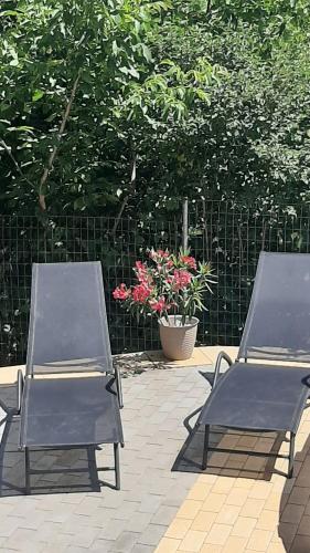 two chairs sitting next to a fence with a plant at Onix- Kis-tó Apartman ORFŰ in Orfű