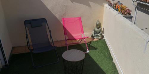 a small room with a pink chair and a statue at Maison avec jacuzzi in Saint-Mitre-les-Remparts