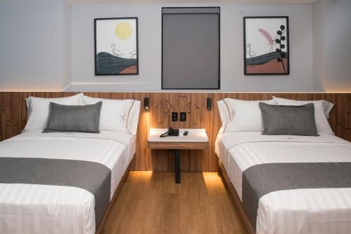 a room with two beds and a table in it at Hotel Flamencos Centro Histórico in Mexico City