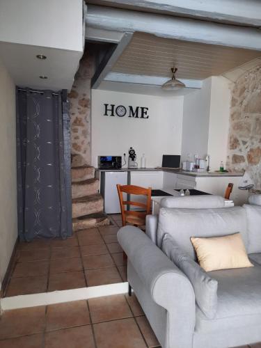 un soggiorno con due divani e una cucina di Maison avec jacuzzi a Saint-Mitre-les-Remparts