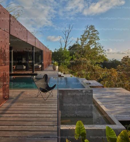 a chair sitting on a boardwalk next to a building at Art Villas Costa Rica, Villas & Glamping in Uvita