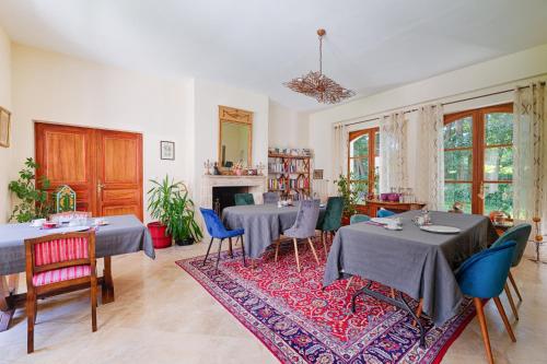 ein Esszimmer mit Tischen und blauen Stühlen in der Unterkunft Domaine De La Tour in Saint-Pierre-Canivet