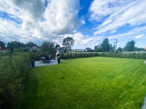 a person standing in a yard with a grass field at Pod Czwórką in Rewa