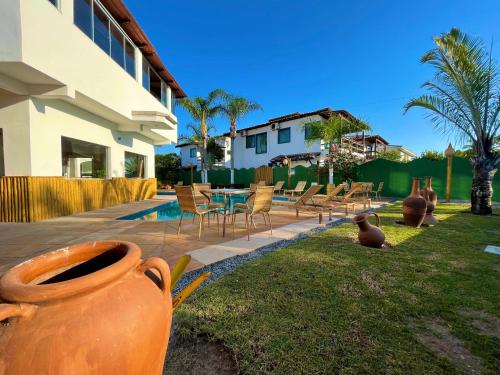 a patio with chairs and a table in a yard at MUTA PRAIA HOTEL in Porto Seguro
