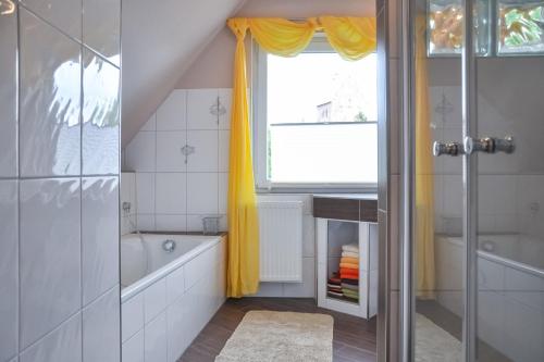 a bathroom with a tub and a sink and a window at Auszeit Wrixum in Boldixum