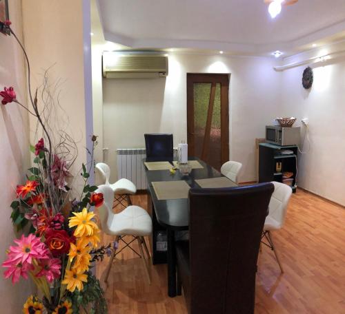 a dining room with a table and chairs and flowers at 3-Room Delta Modern Residence in Tulcea