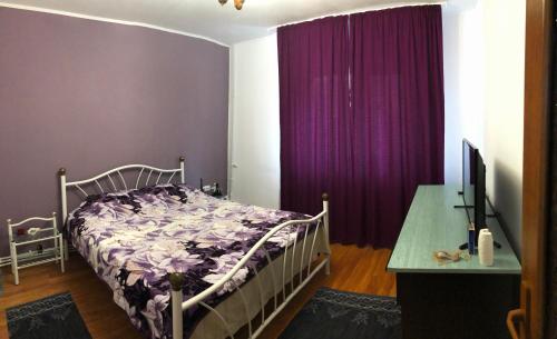 um quarto com uma cama e cortinas roxas em 3-Room Delta Modern Residence em Tulcea