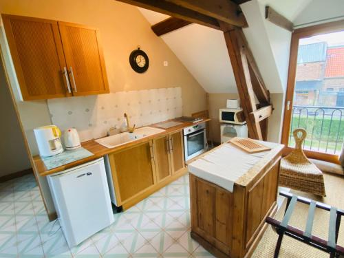 a kitchen with wooden cabinets and a counter top at Ferme de Montecouvez in Crèvecoeur-sur-lʼEscaut