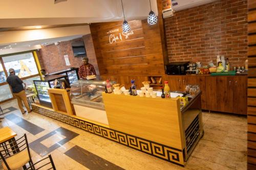 a restaurant with a bar with a man standing behind it at Kohinoor Hotels in Erode