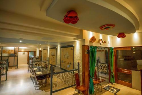 a restaurant with tables and chairs in a room at Kohinoor Hotels in Erode