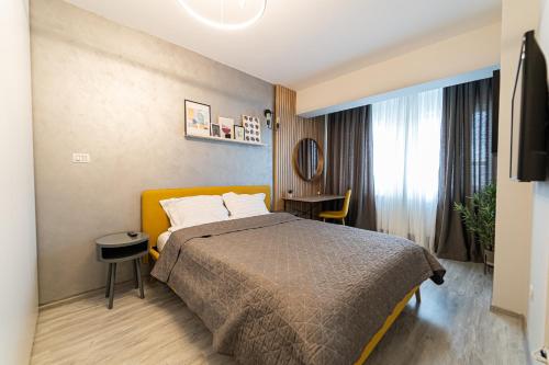a hotel room with a bed and a table at Apartament Deluxe cu parcare gratuită, lângă Arena Mall in Centru Bacău - ideal pentru cupluri sau business in Bacău