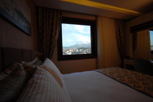 a bedroom with a bed and a window with a view at Imamoglu Pasa Butik Hotel in Kayseri