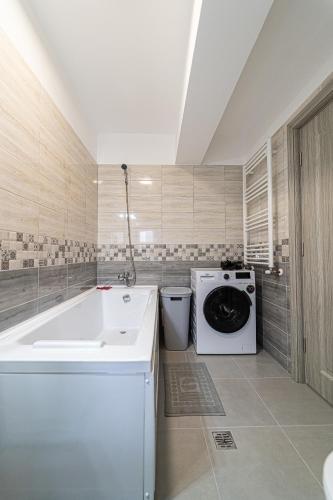 a bathroom with a washing machine and a sink at Delux Suite - Apartament 100 de m2 cu 3 camere și parcare gratuită, lângă Arena Mall in Centrul Bacău in Bacău