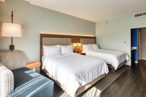 a hotel room with two beds and a couch at Holiday Inn Express & Suites - Charlotte - South End by IHG in Charlotte