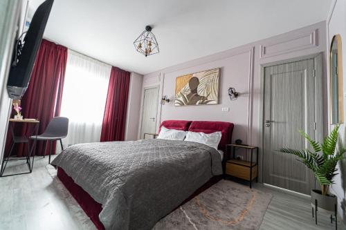 a bedroom with a bed with a red headboard at Delux Suite - Apartament 100 de m2 cu 3 camere și parcare gratuită, lângă Arena Mall in Centrul Bacău in Bacău
