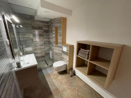 La salle de bains est pourvue de toilettes, d'un lavabo et d'une douche. dans l'établissement Apartma 7 - In the heart of Soča Valley, à Tolmin