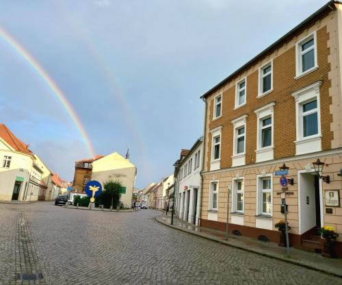 a rainbow in the middle of a street with buildings at SPREE Hotel in der Altstadt in Lübbenau