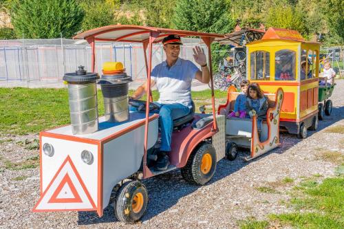 un hombre y un niño en un pequeño tren en Ninemia Stay and Play, en Karpenisi