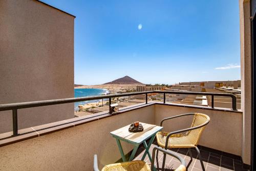 エル・メダノにあるalquilaencanarias El Medano Spectacular terrace and sea views Aのビーチの景色を望むバルコニー(テーブル、椅子付)