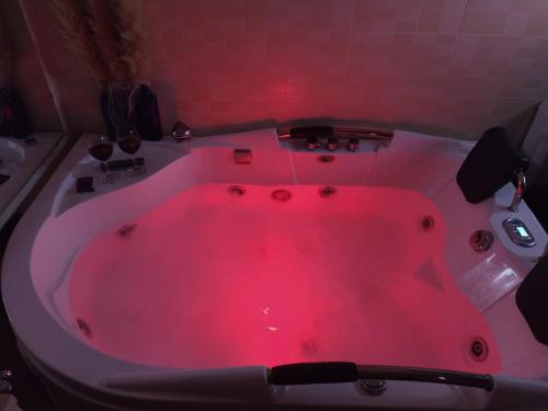 y baño con bañera con luz roja. en Ático spa rural en Alcarraz