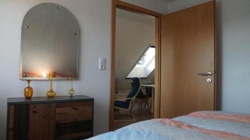 - une chambre avec un miroir et une commode avec un lit dans l'établissement Pension Limone Ferienwohnung 1, à Neu Lindenberg