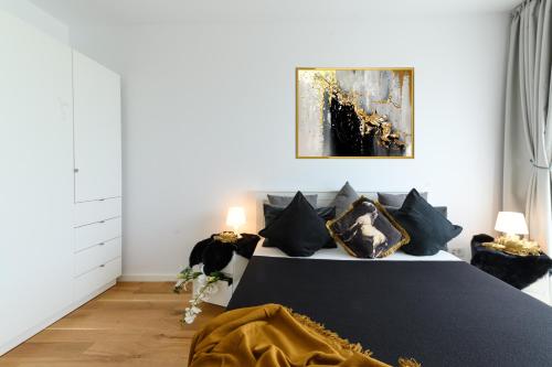um quarto com uma cama com almofadas pretas e um quadro em North Artistique - Aviatiei em Bucareste