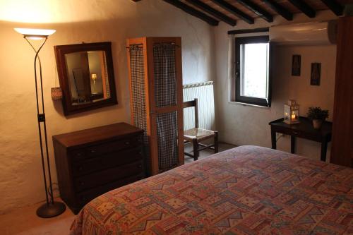 a bedroom with a bed and a mirror and a dresser at Petite Maison in Cetona