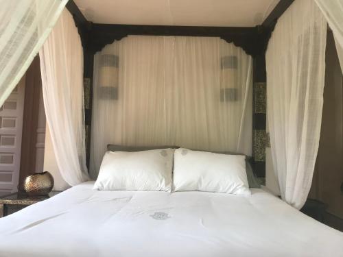 a bed with white sheets and pillows in a bedroom at Villa #1 ‘Rosalie’ in Marrakech