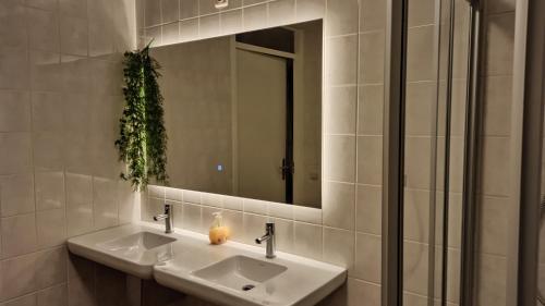 een badkamer met 2 wastafels en een spiegel bij Breakfast at Carin’s in Vlissingen