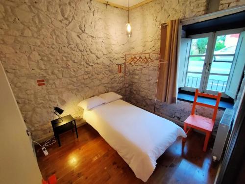 een slaapkamer met een wit bed en een raam bij Ca Borines in Borines