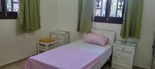 a small room with a bed with a pink pillow at DREAM ISLAND Hotel in Luxor