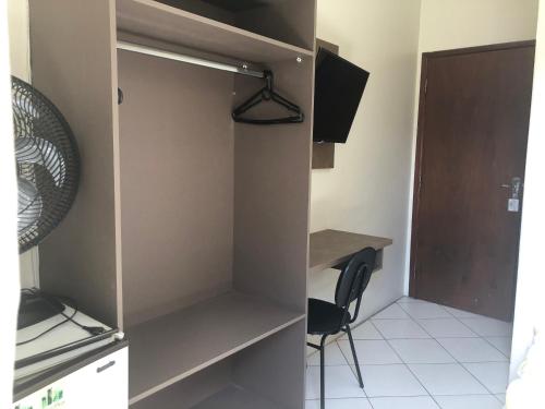 a room with a desk and a table and a chair at Hotel de Minas in Caxambu