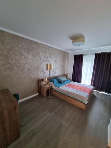een slaapkamer met een bed en een tafel met een lamp bij Apartament SUPERB in regim Hotelier- Arad Plaza in Arad