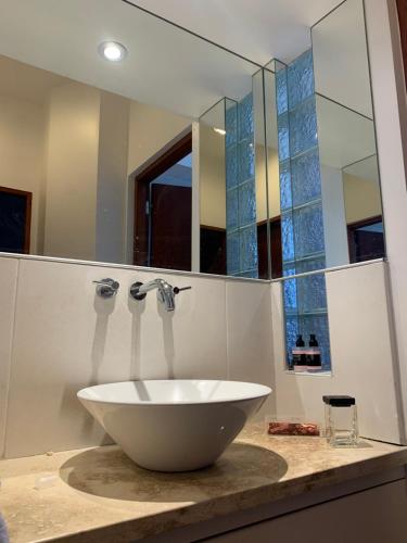 Un baño con un lavabo blanco y un espejo. en Mirador Salta I Vistas panorámicas, en Salta