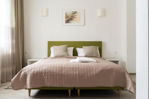 sypialnia z dużym łóżkiem z zielonym zagłówkiem w obiekcie 1 House Between Two Lakes w Wilnie