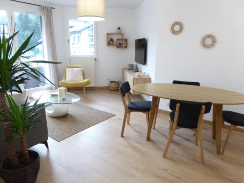 a living room with a dining room table and chairs at ALPINES 2 /près du funiculaire et gare sncf-garage privé-terrasse sud-46m2 in Bourg-Saint-Maurice