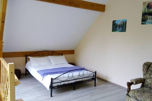 a bedroom with a bed and a chair at Duplex at the foothills of the Pyrenees in Geu