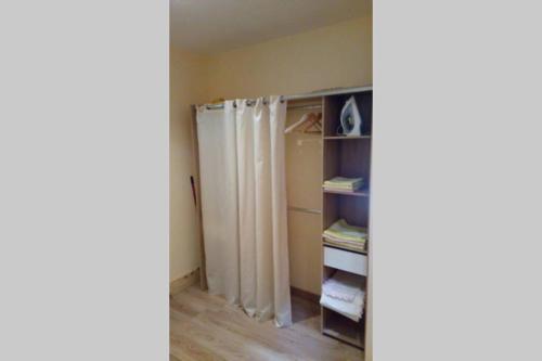 a closet with a shower curtain in a room at Duplex at the foothills of the Pyrenees in Geu