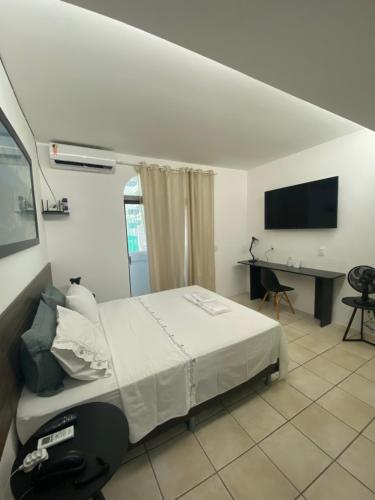 a bedroom with a bed and a desk and a television at Flat beira mar, Olinda 4 Rodas 203 in Olinda