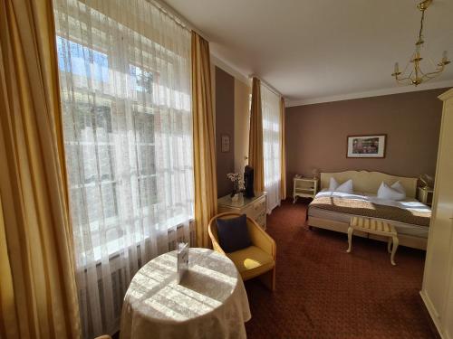 a bedroom with a bed and a large window at Landhotel in Mühltroff