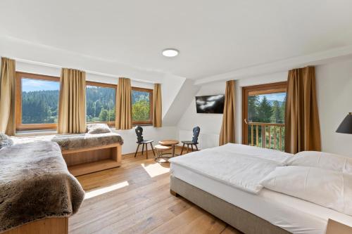 a bedroom with two beds and a large window at Köhlerei am See in Feldberg