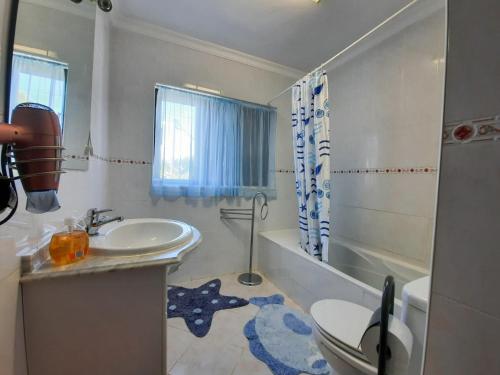 a bathroom with a sink and a toilet and a tub at Villa Quinta do Algarve in Albufeira