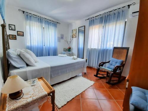 a bedroom with a bed and a chair and a table at Villa Quinta do Algarve in Albufeira