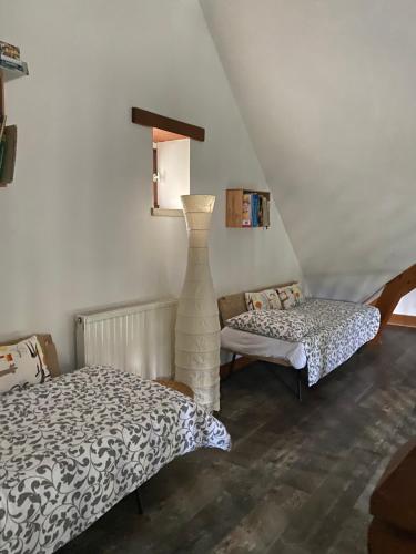 - une chambre avec un lit et un vase dans l'établissement Les 2 gites des Chambres de Capucine, à Carcagny