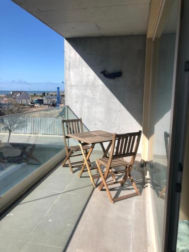 un tavolo e 2 sedie seduti su un balcone di Cozy canide beach apartment a Canidelo